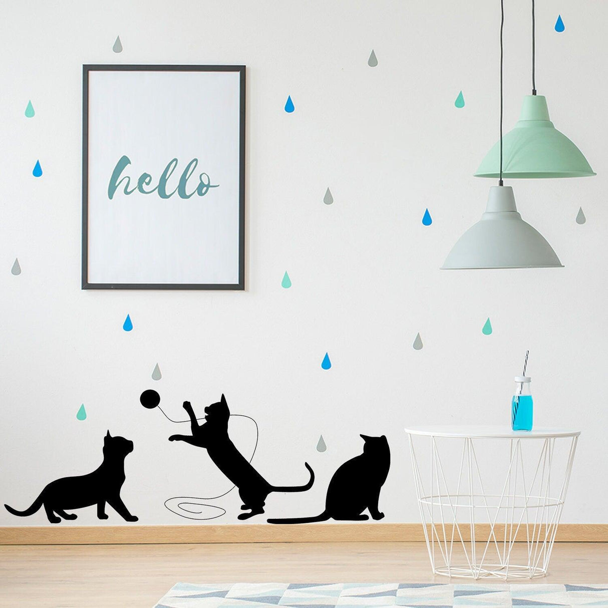 Wall art featuring playful black cat silhouettes, a stylish light fixture, and a cheerful 'hello' print.