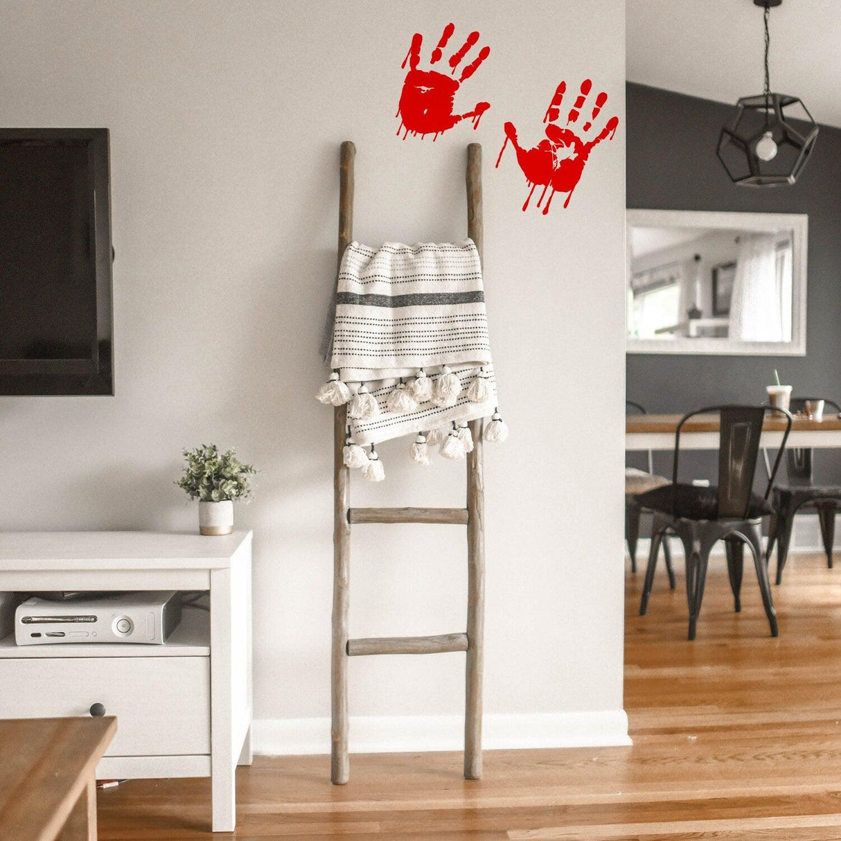 8" bloody hands decal on the wall above a wooden ladder, creating a spooky atmosphere for Halloween decor.