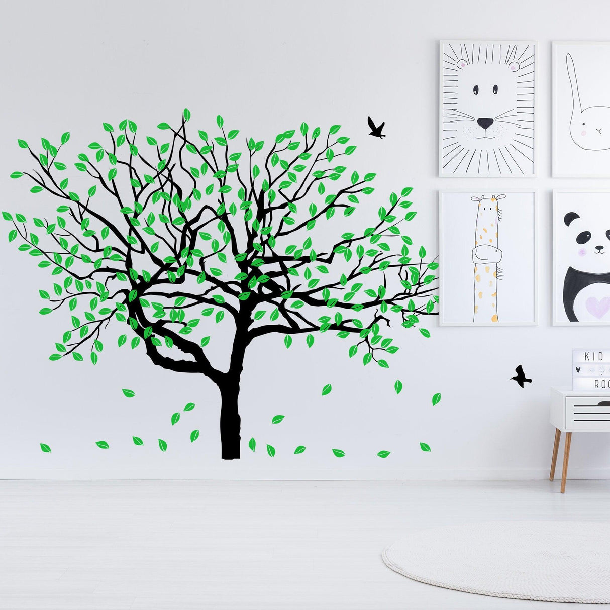 Stylish tree wall decal featuring green leaves and black trunk, perfect for nursery or home decor.