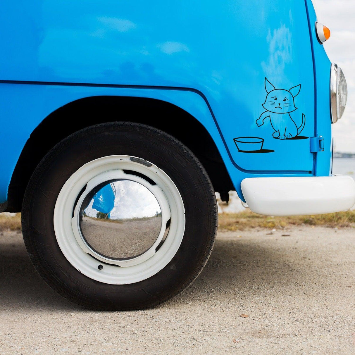 Blue vintage car with a cute cat illustration near the wheel, highlighting a playful and fun vehicle design.