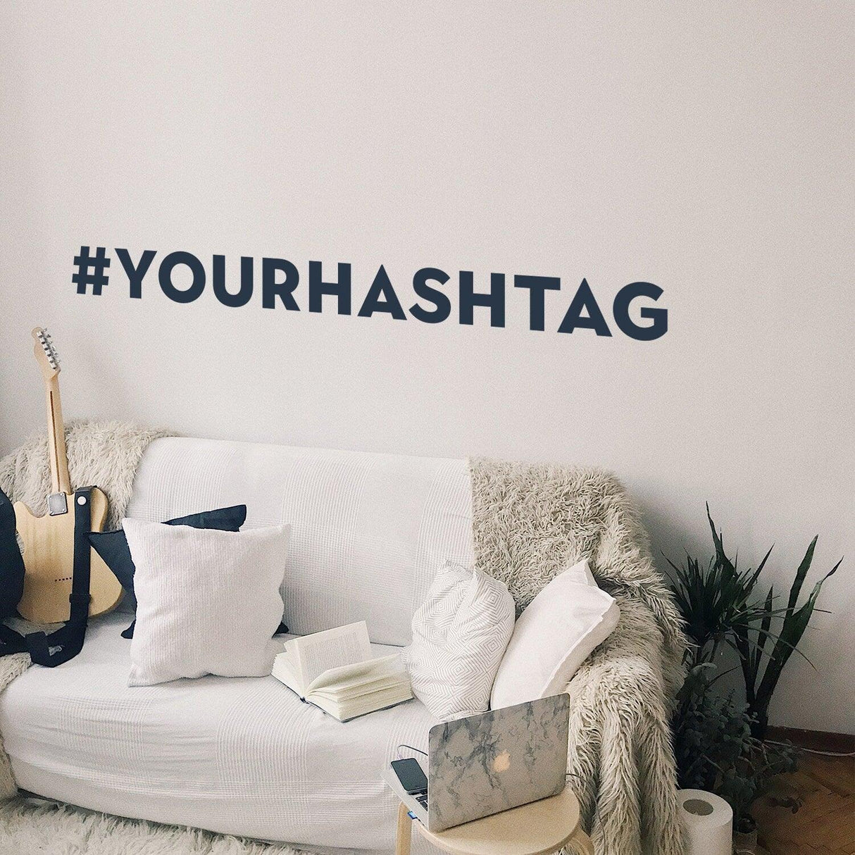 Custom hashtag vinyl sticker displayed on a wall above a cozy couch, enhancing social media decor.