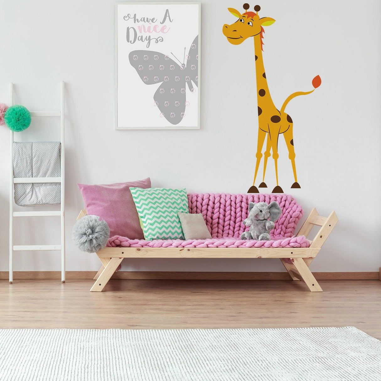 Cute nursery giraffe vinyl wall sticker next to a cozy pink couch and butterfly art.