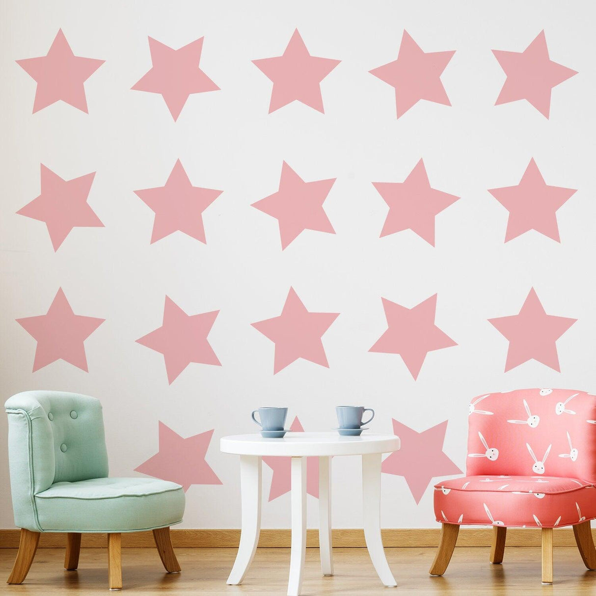 Pink star wall decals in a baby nursery with a table and chairs, perfect for baby shower decor.