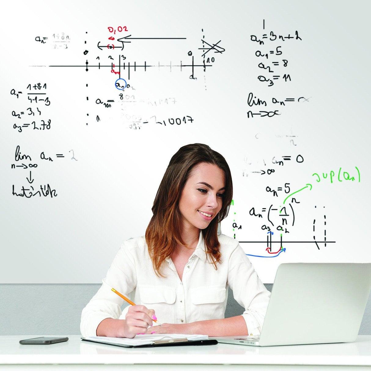 Woman studying at a desk with a whiteboard sticker displaying math equations and notes.