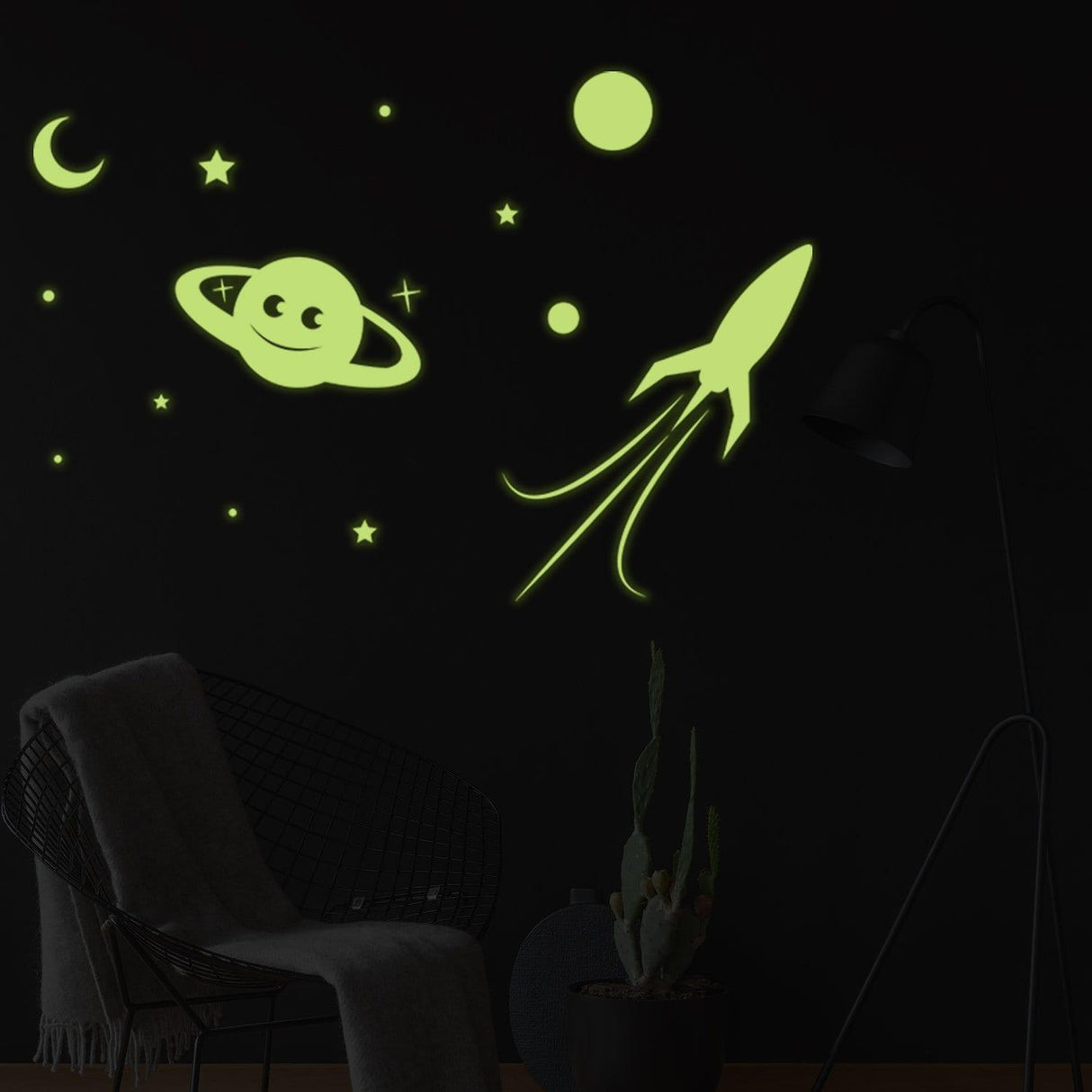 Glowing planet, rocket, stars, and moon wall decal on dark ceiling; perfect for creating a magical space ambiance.