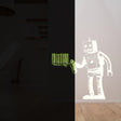 Glow in the dark wall sticker of a robot interacting with a luminescent barcode design, perfect for kids' rooms.