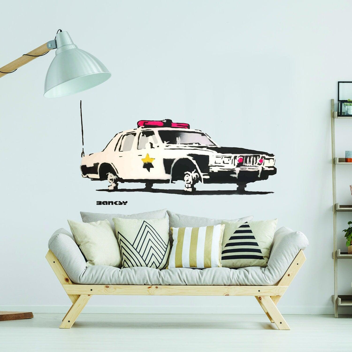 Police car vinyl wall sticker decal featuring vibrant design beside stylish couch in modern living room.