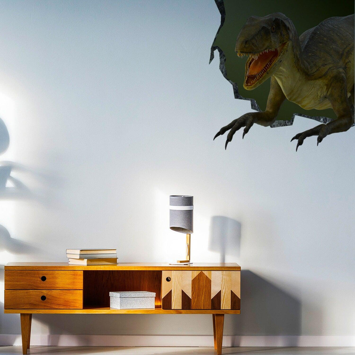 3D dinosaur wall sticker breaking through a wall above a modern wooden cabinet and lamp.