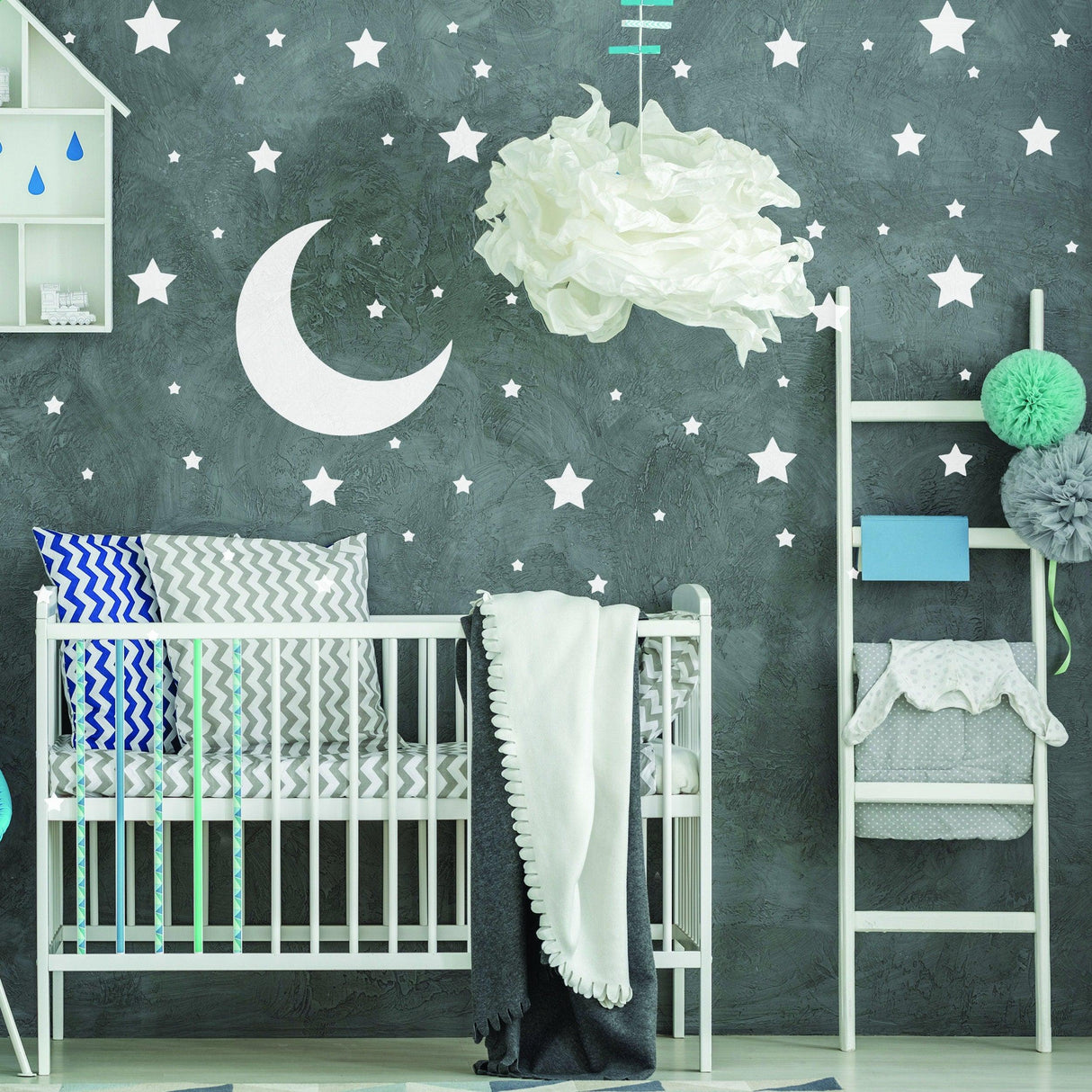 Nursery room with white star wall stickers and a moon decal above a crib, featuring cozy bedding and decorative accents.