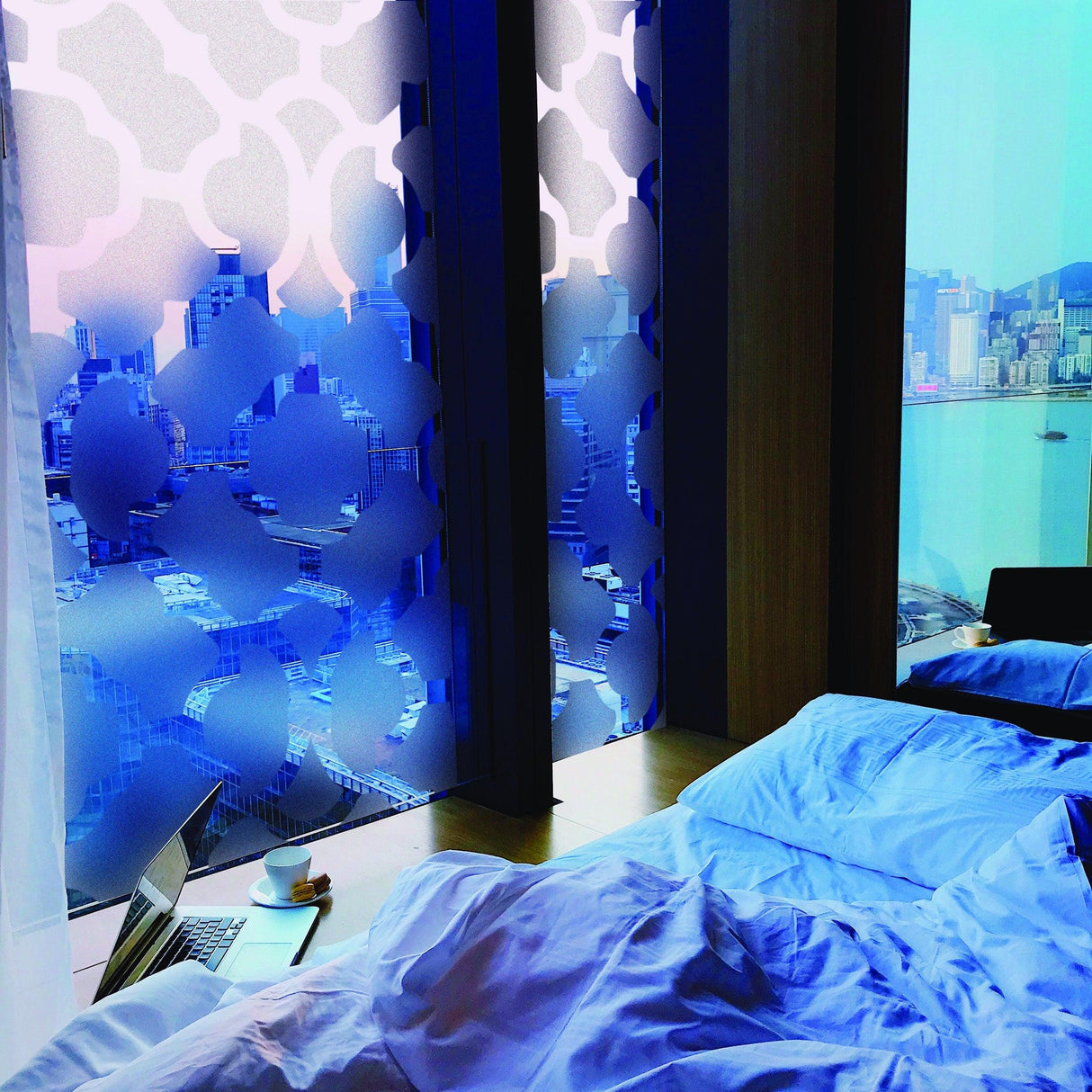 Frosted door film vinyl decal in bedroom window providing privacy with city view, styled with blue bedding.