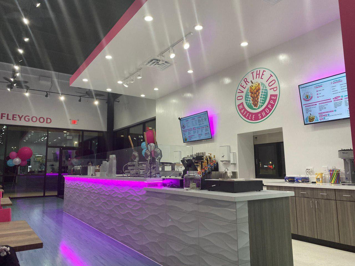 Interior view of Over the Top Ice Cream Shop with bright lights, modern decor, and a welcoming atmosphere.