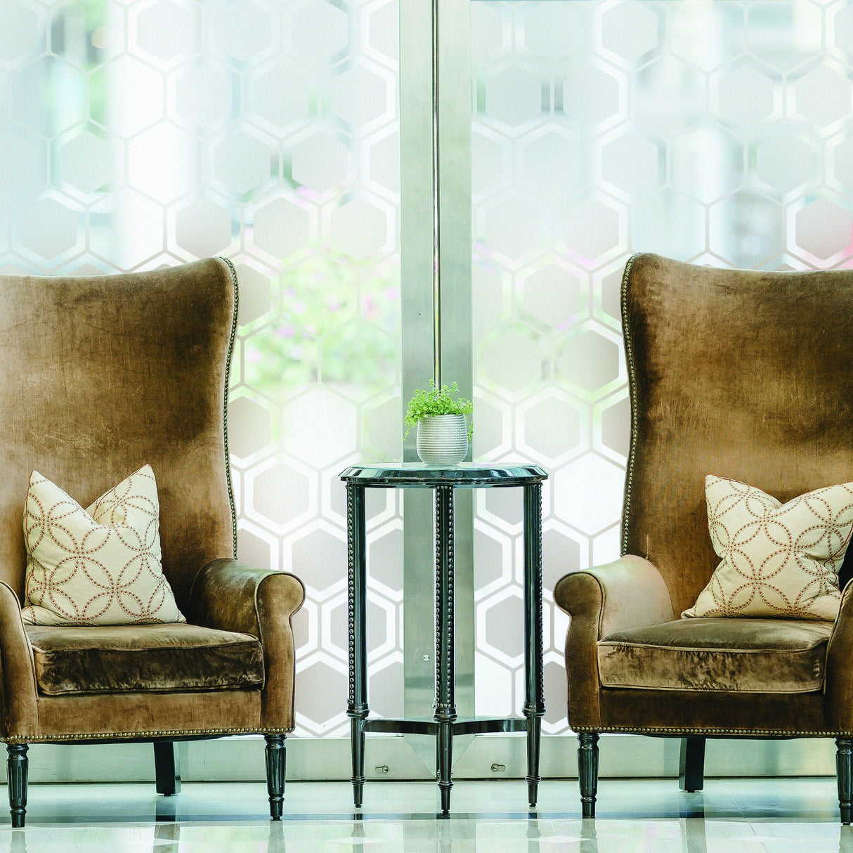 Elegant living room featuring two high-back chairs with stylish cushions and a decorative table, set behind frosted window film.