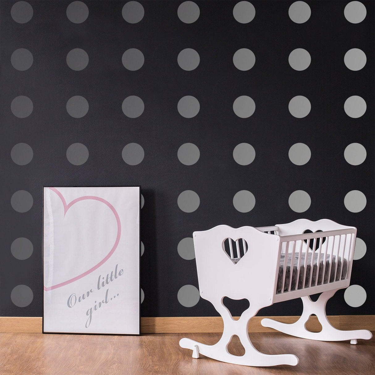 Stylish nursery featuring gray circle wall decals, a white rocking crib, and framed decor for a chic look.