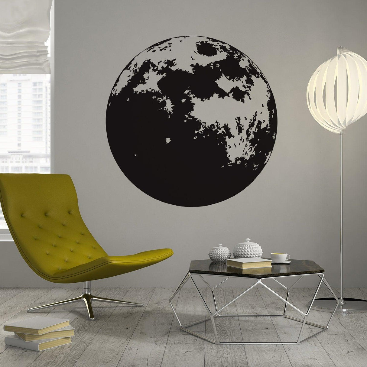 Large black moon wall decal in a modern nursery with yellow chair and stylish decor.