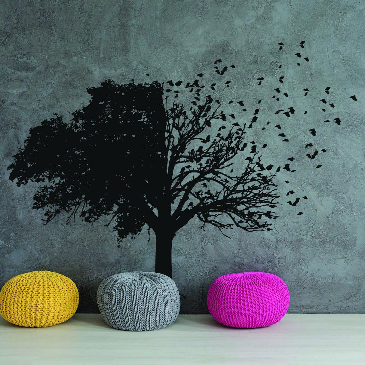 Black tree wall decal with birds and colorful poufs in a modern living room decor.