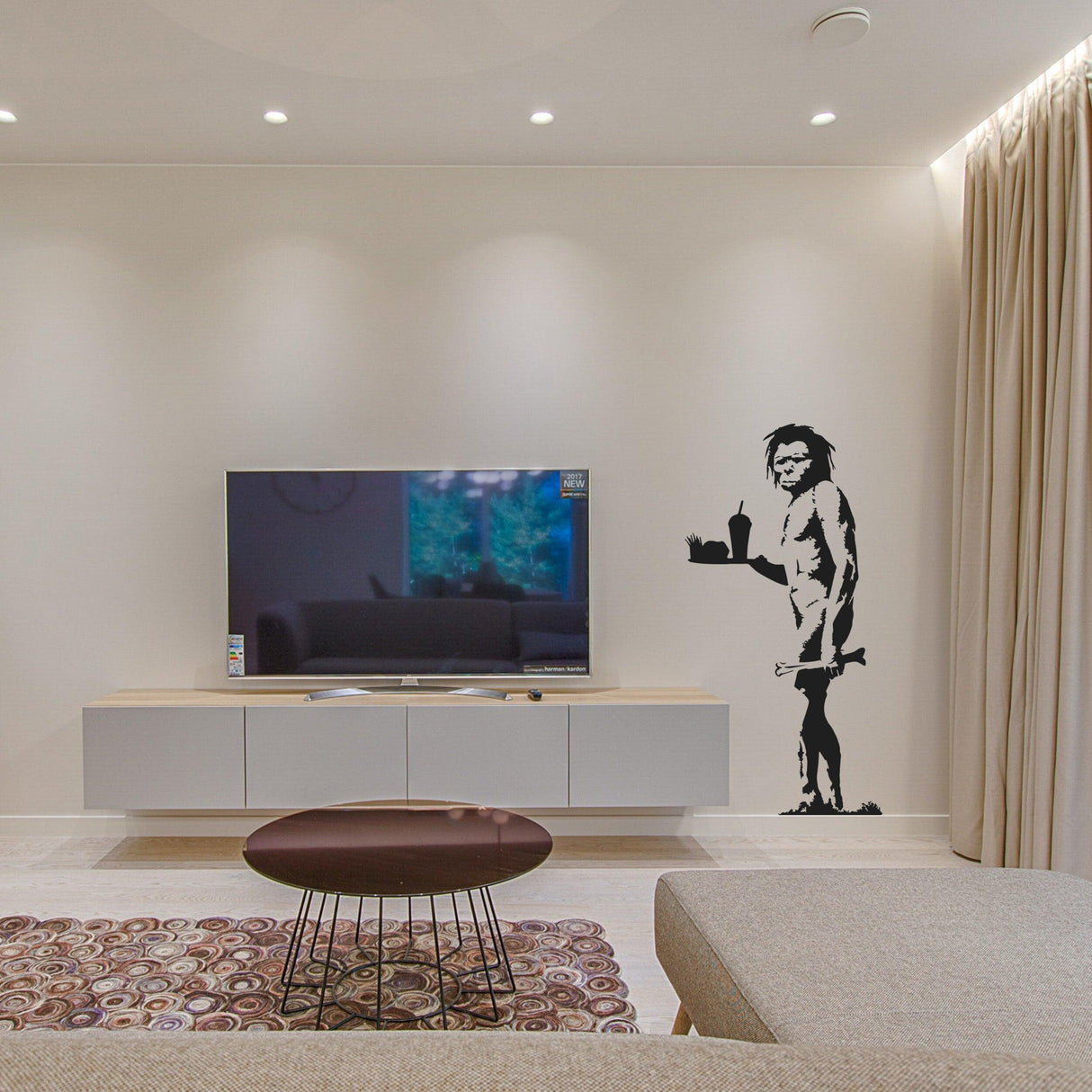 Banksy Caveman Art graffiti vinyl wall decal on a living room wall, modern decor with black and white design.