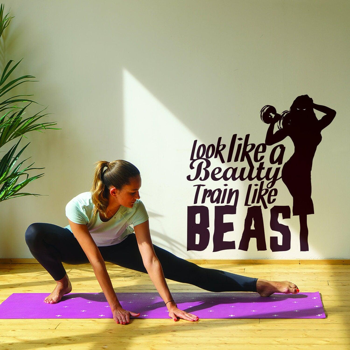 Motivational gym wall decal "Look like a Beauty, Train like a Beast" with a woman doing yoga stretches.