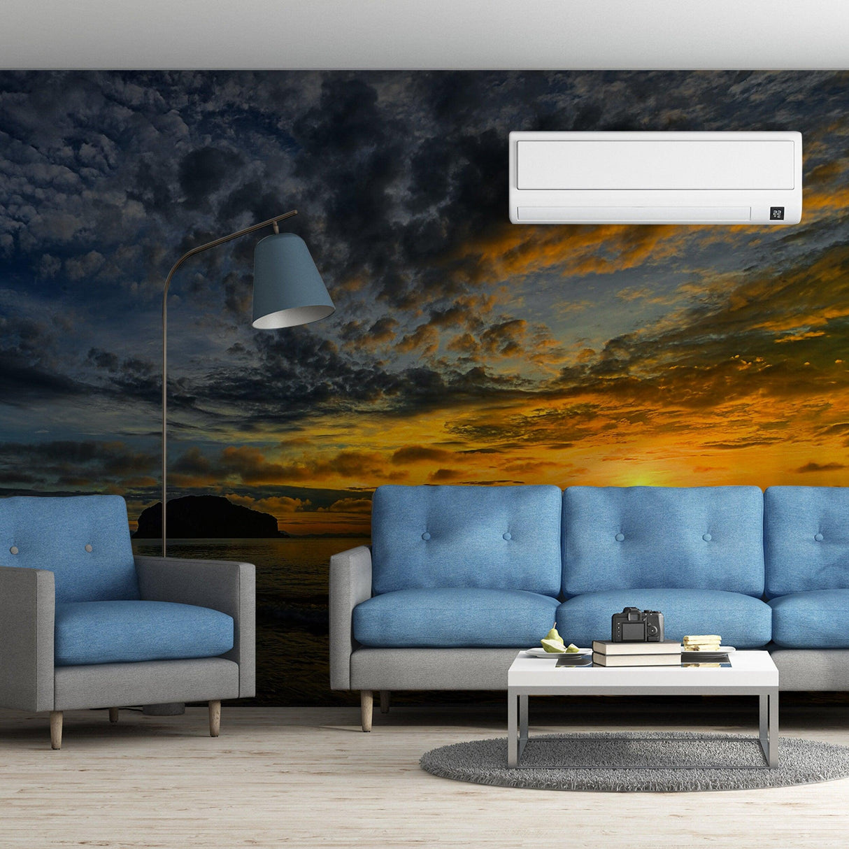 Sunset wallpaper mural in a modern living room with blue couches and stylish decor.