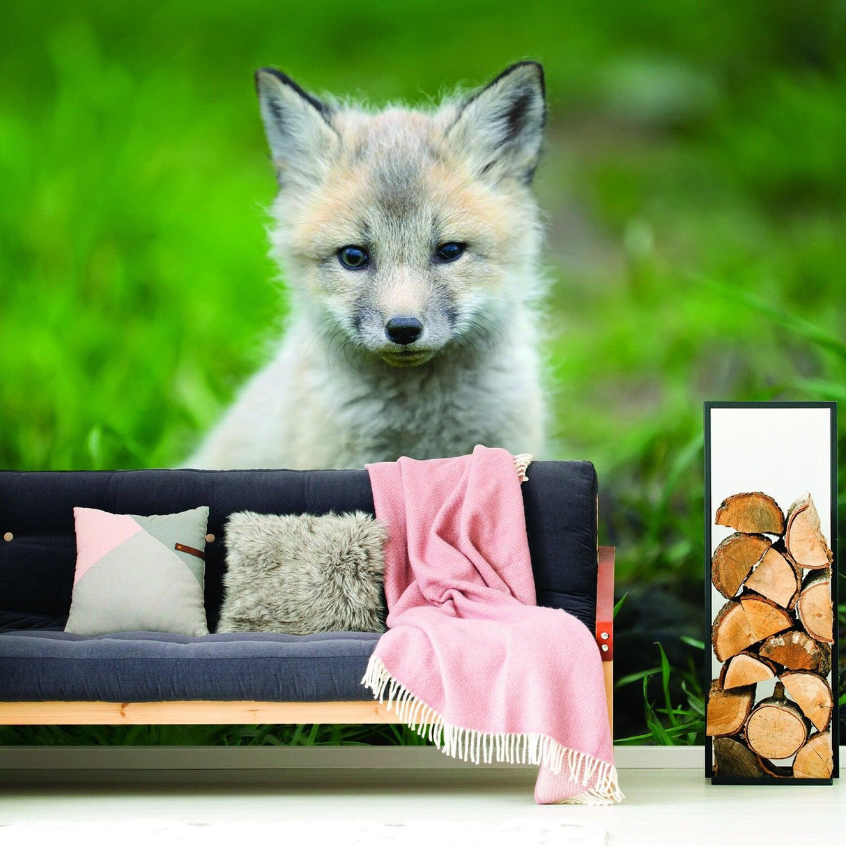 Cute little fox wallpaper decor decal in nursery with pink blanket on couch and wood storage.