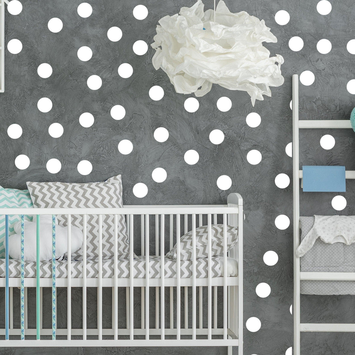 Stylish baby nursery featuring white circle wall stickers on grey wall, creating a modern and playful decor.