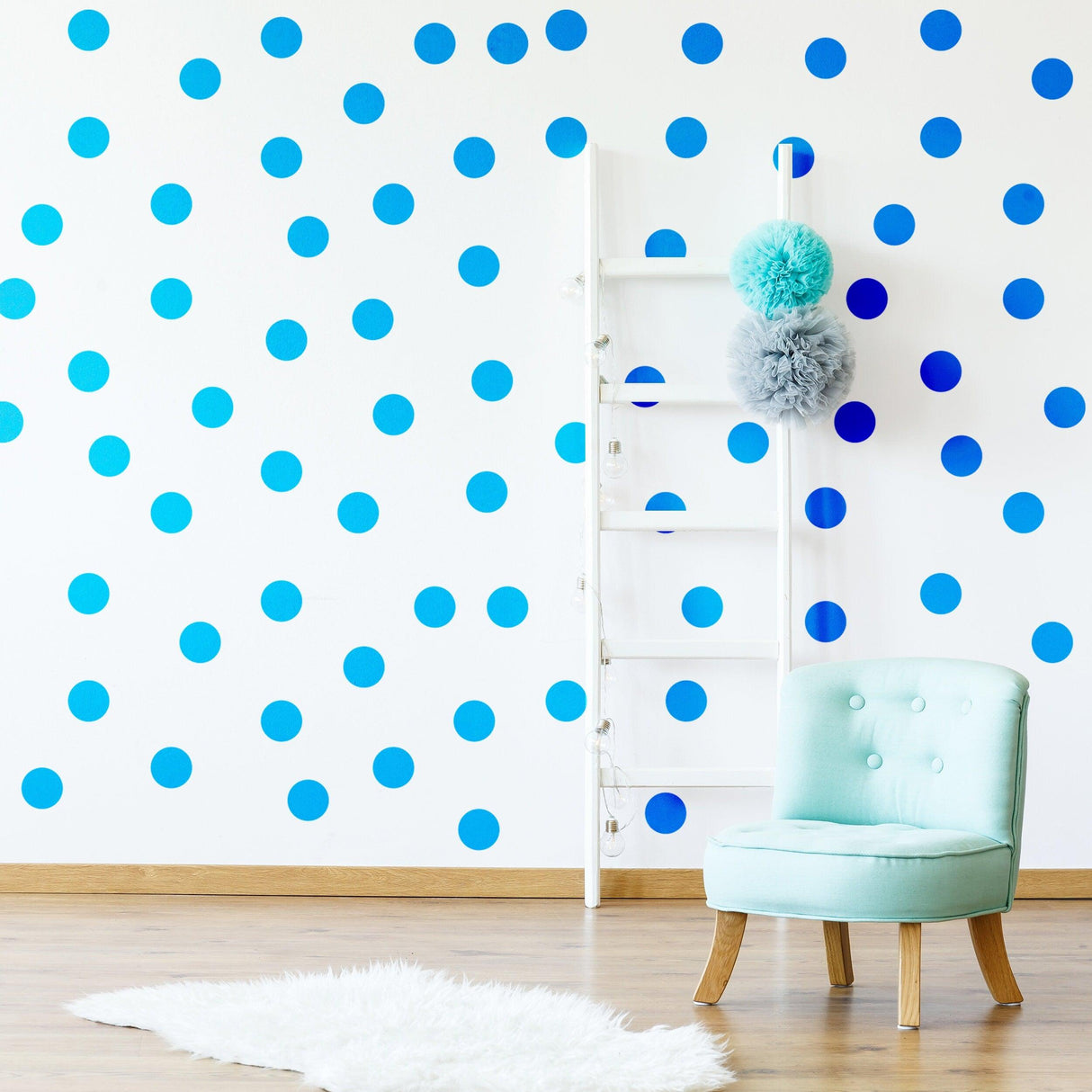 Blue circle wall stickers in various shades on a white wall, featuring a mint green chair and ladder decor.