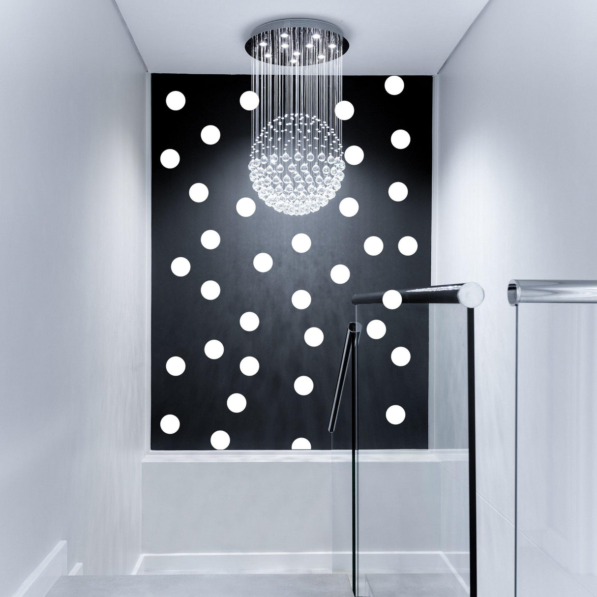 Stylish hallway with a black wall featuring white round dot patterns and a modern chandelier overhead.