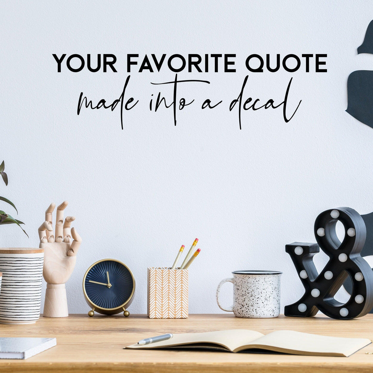 Customized wall decal with personalized quote in stylish font above a modern workspace.