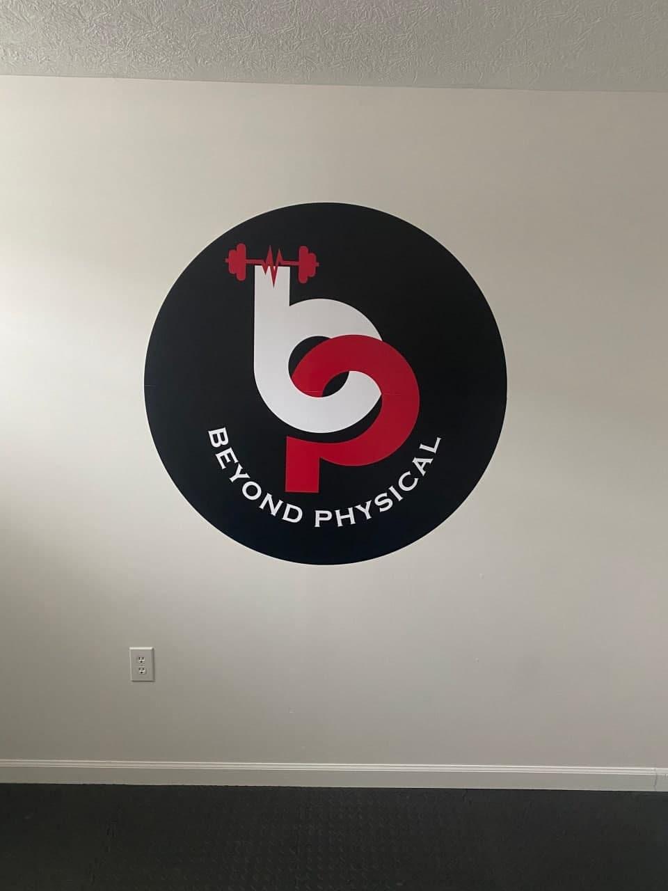 Custom wall decal logo for Beyond Physical gym, featuring bold colors and fitness elements.