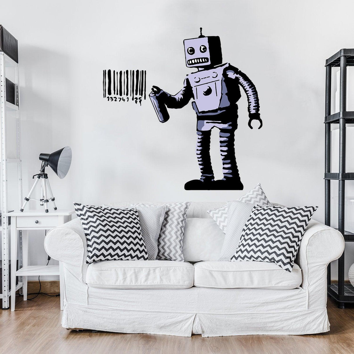 Banksy Barcode Robot Wall Vinyl Sticker on a white wall above a cozy couch with patterned pillows.