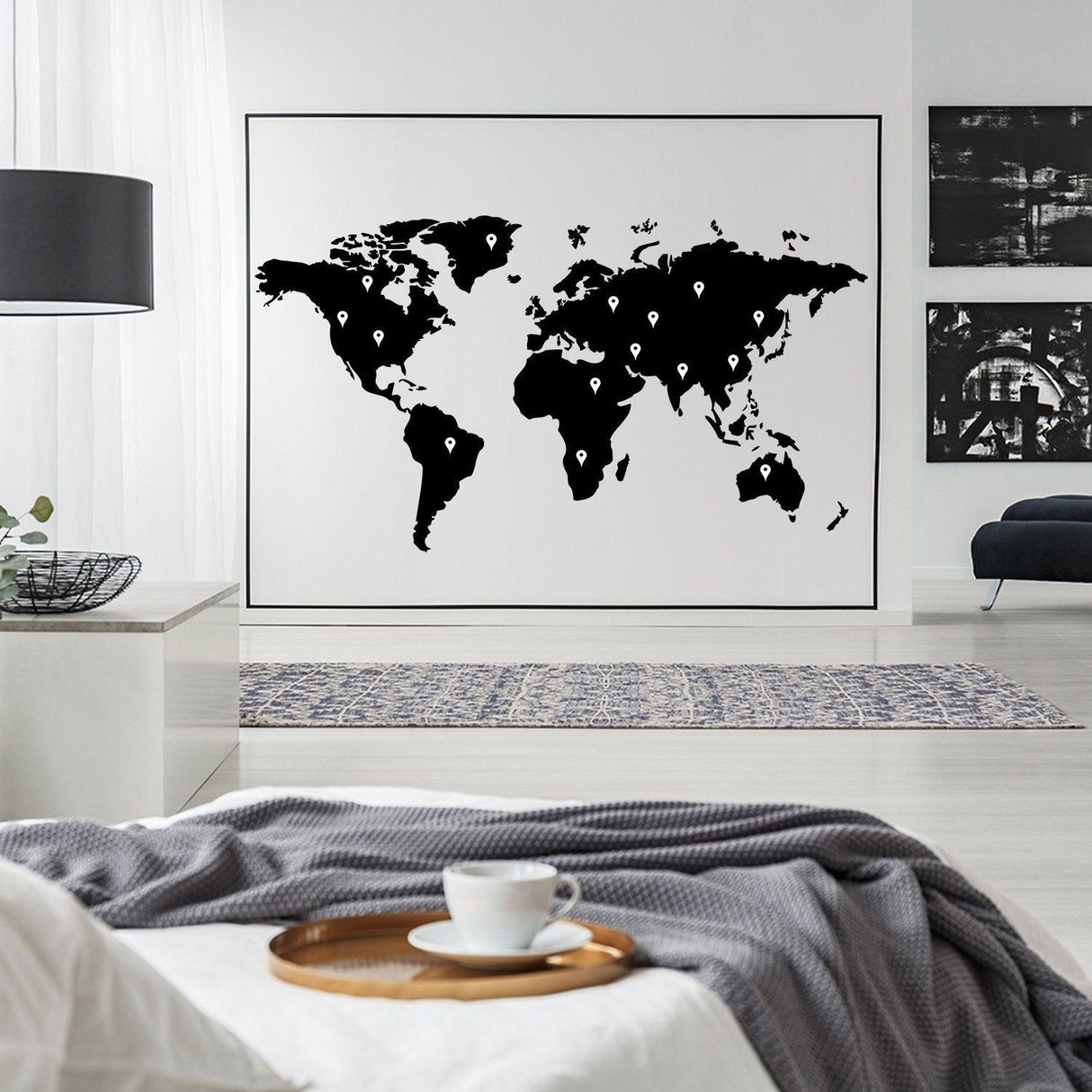 Large world map wall decal in black on a white wall, enhancing the decor of a modern living space.