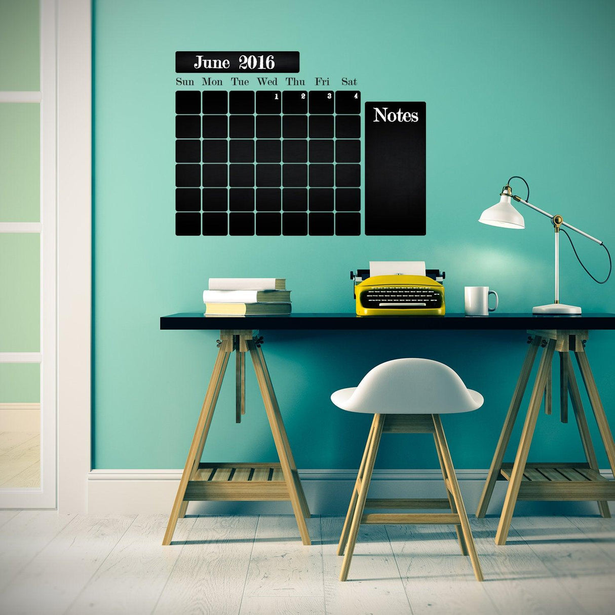 Chalkboard wall planner with monthly calendar and notes section in a stylish kitchen workspace.