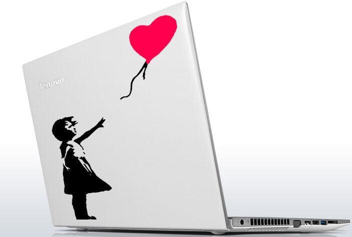 Banksy Girl With The Red Balloon vinyl sticker on a laptop, showcasing street art design and vibrant colors.