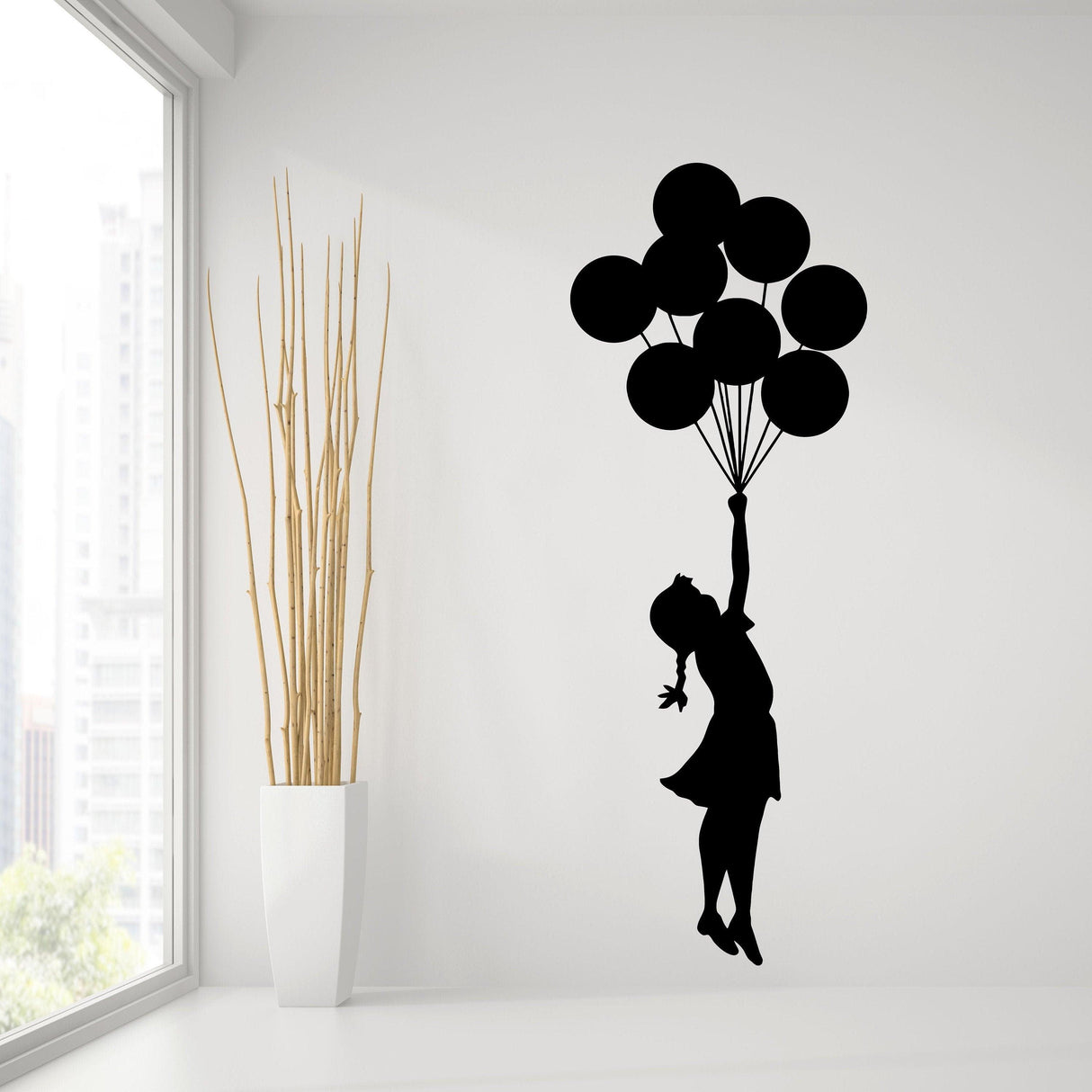 Banksy-inspired wall decal of a girl holding heart-shaped balloons in a modern room setting.