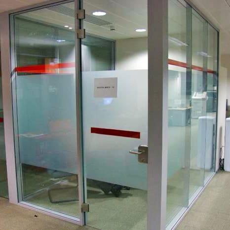 Frosted window film decal on glass office doors, enhancing privacy with a modern design.