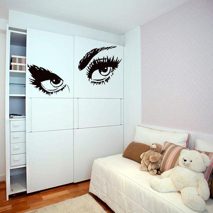 Elegant woman eyes wall sticker decor in a bedroom, showcasing beautiful lashes and eyebrows.