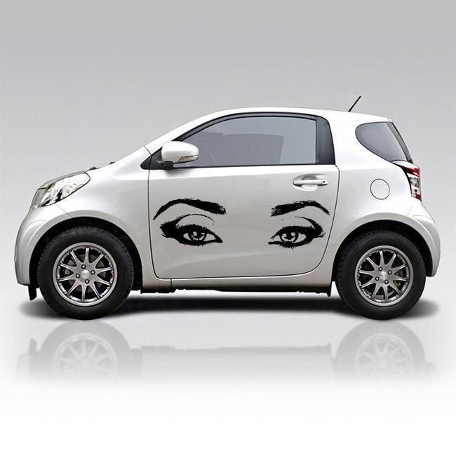 Car with decorative female eye decals on the side, showcasing stylish wall decor for a unique look.