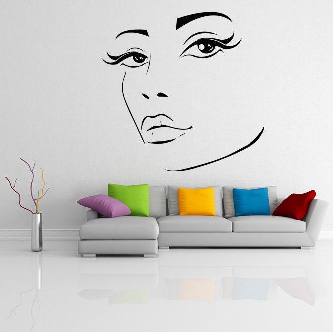 Stylish wall decor featuring a beautiful woman's face with long lashes, enhancing a modern living room's elegance.