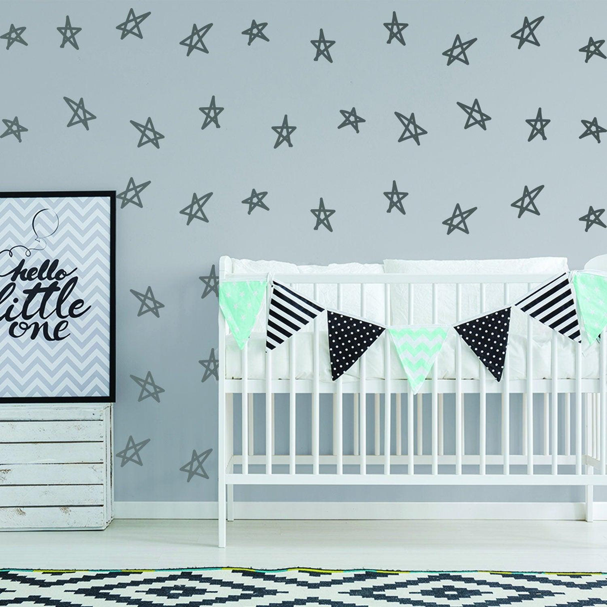 Nursery wall with removable star decals, crib with decorative bunting, and playful art print.