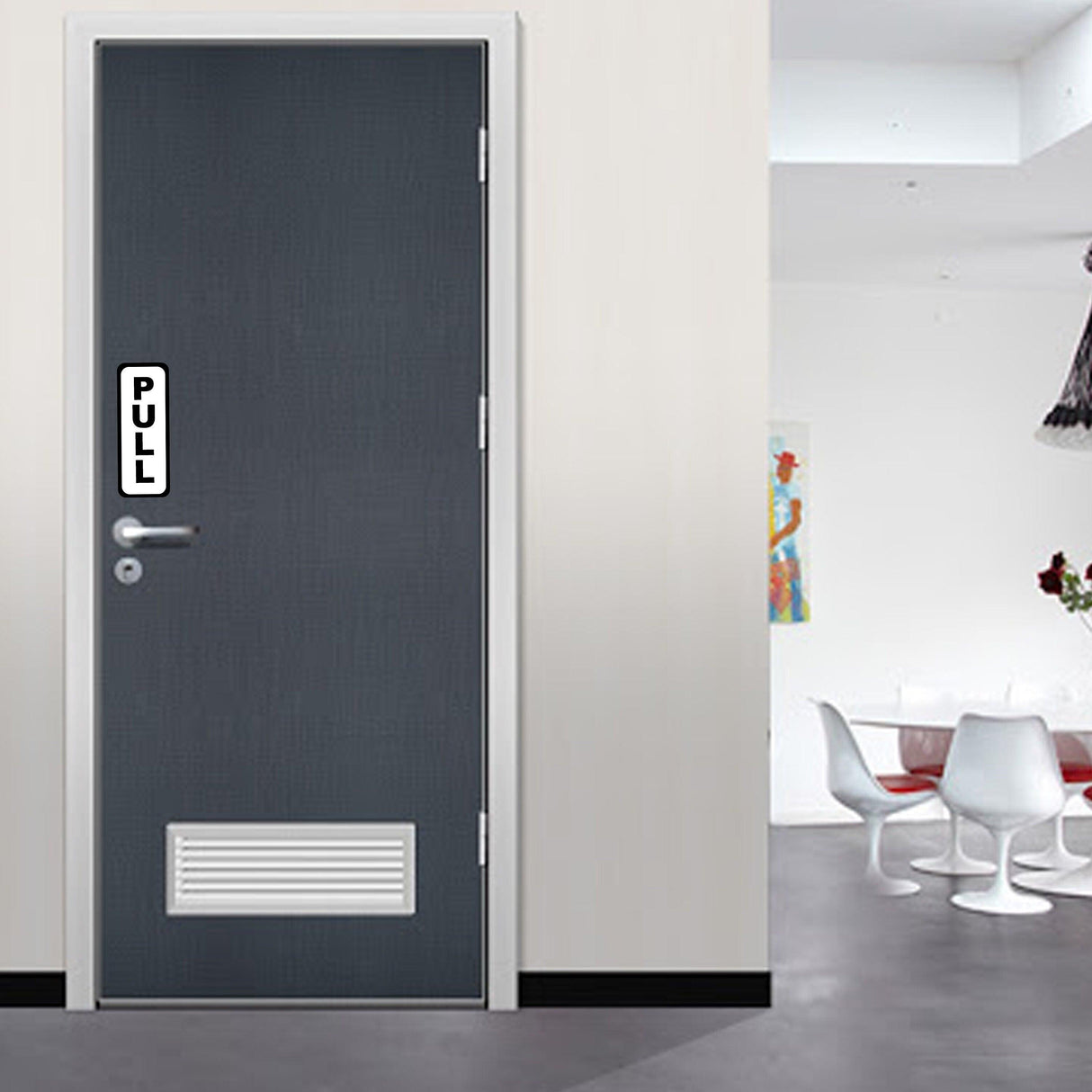 Vertical 'PULL' sign on a gray door in a modern interior setting, indicating door operation.