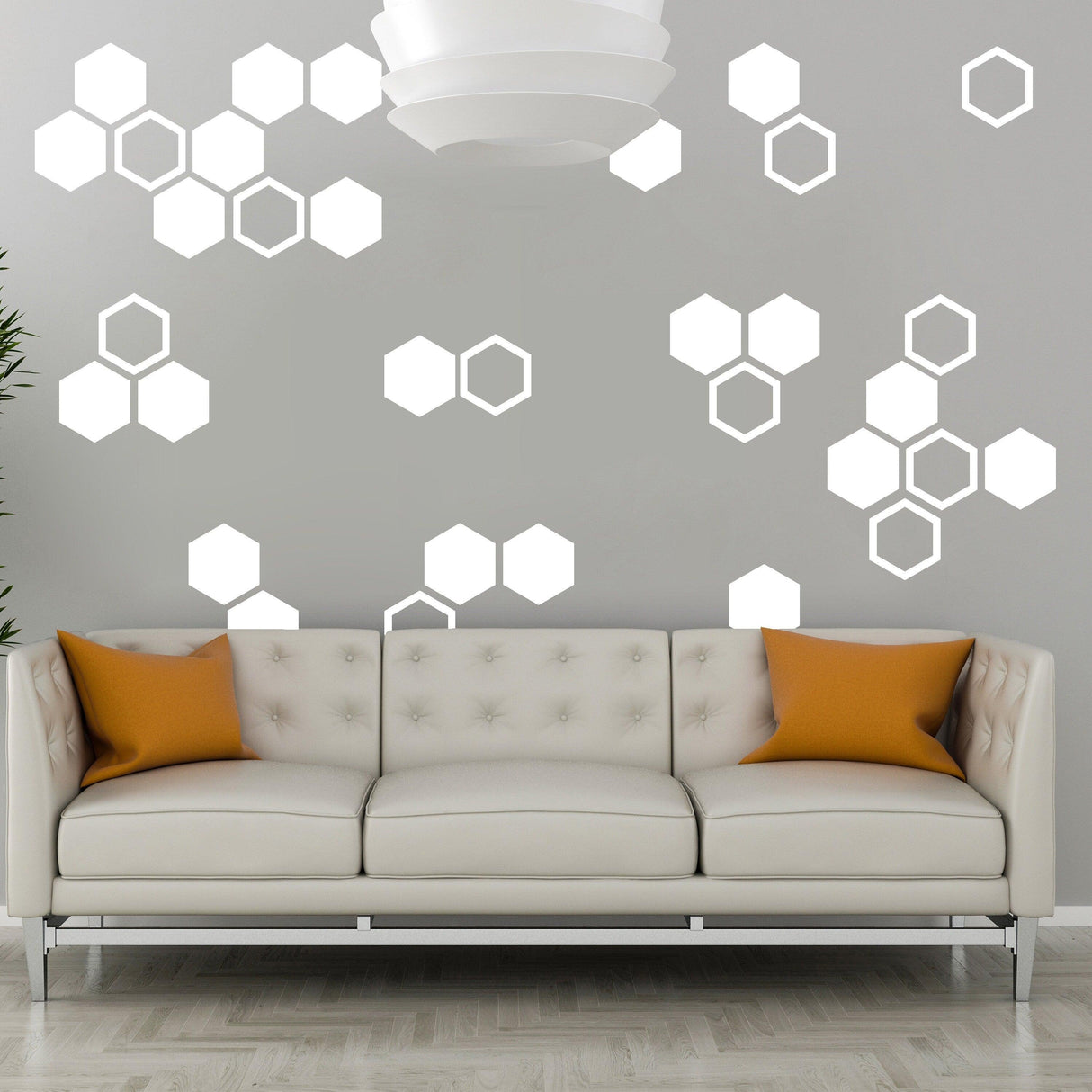 Living room featuring glow in dark honeycomb wall decals and a stylish white sofa with orange cushions.