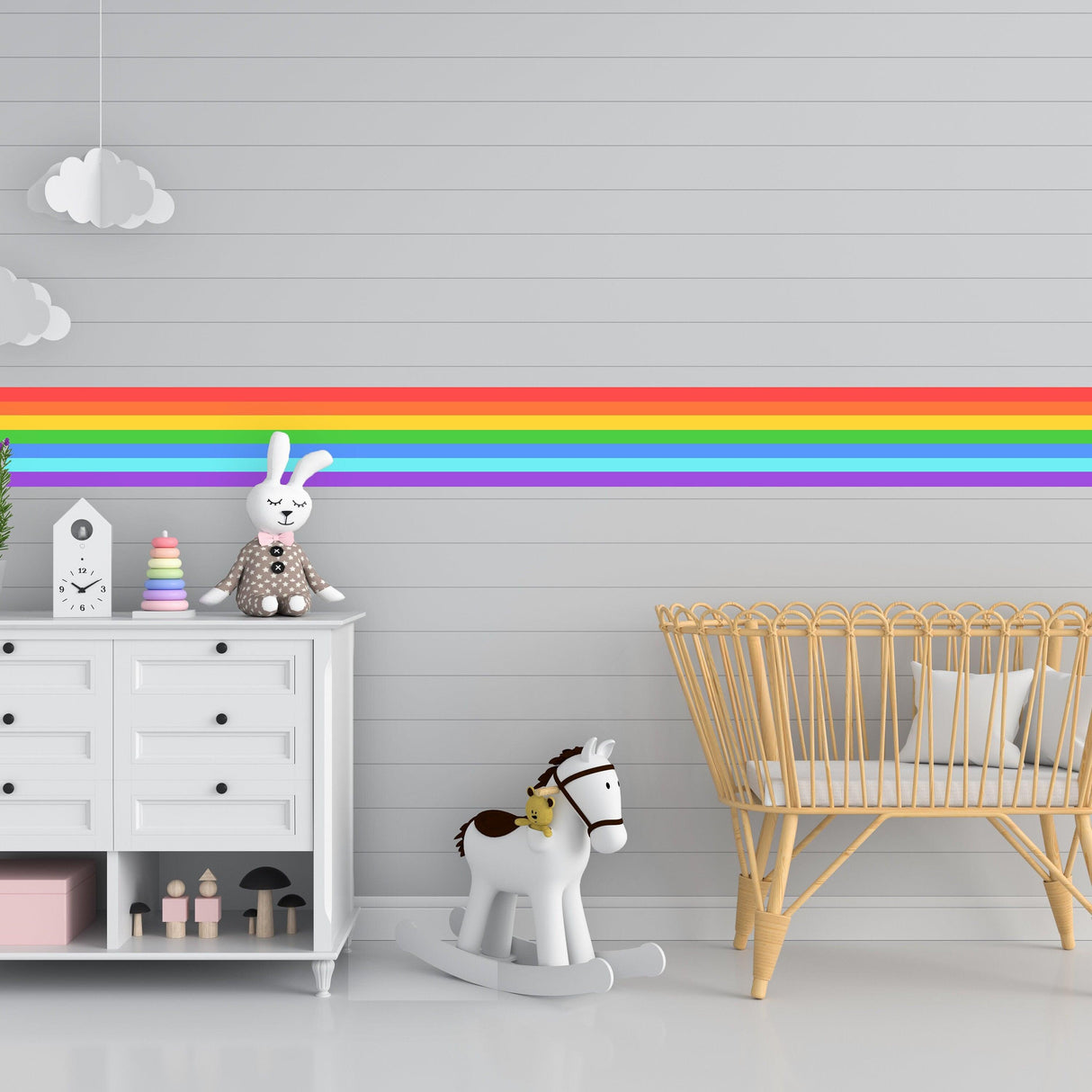 Colorful rainbow stripe vinyl decal on nursery wall with wooden toys and furniture, creating a cheerful atmosphere.