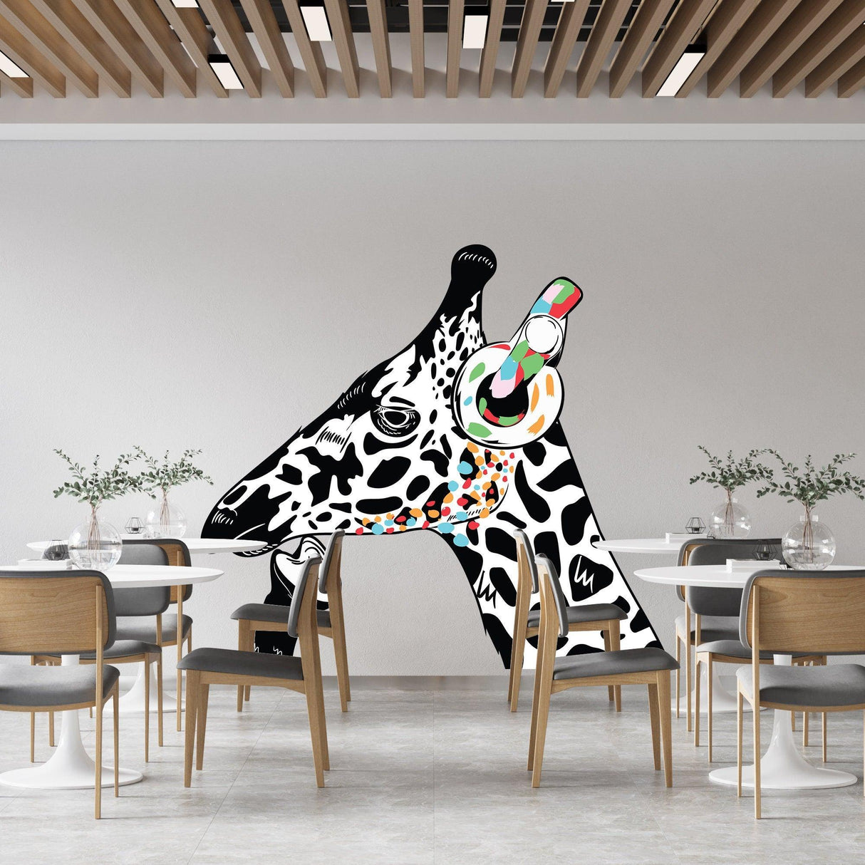 Whimsical giraffe head wall sticker decor in modern dining room with stylish chairs.