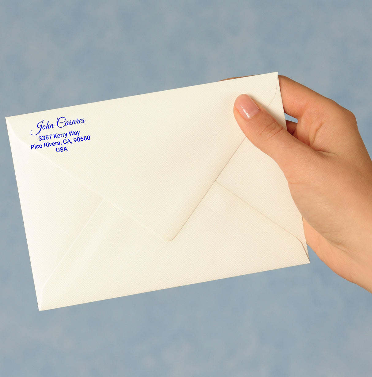 Personalized return address label on an envelope held in a hand, showcasing custom shipping sticker design.