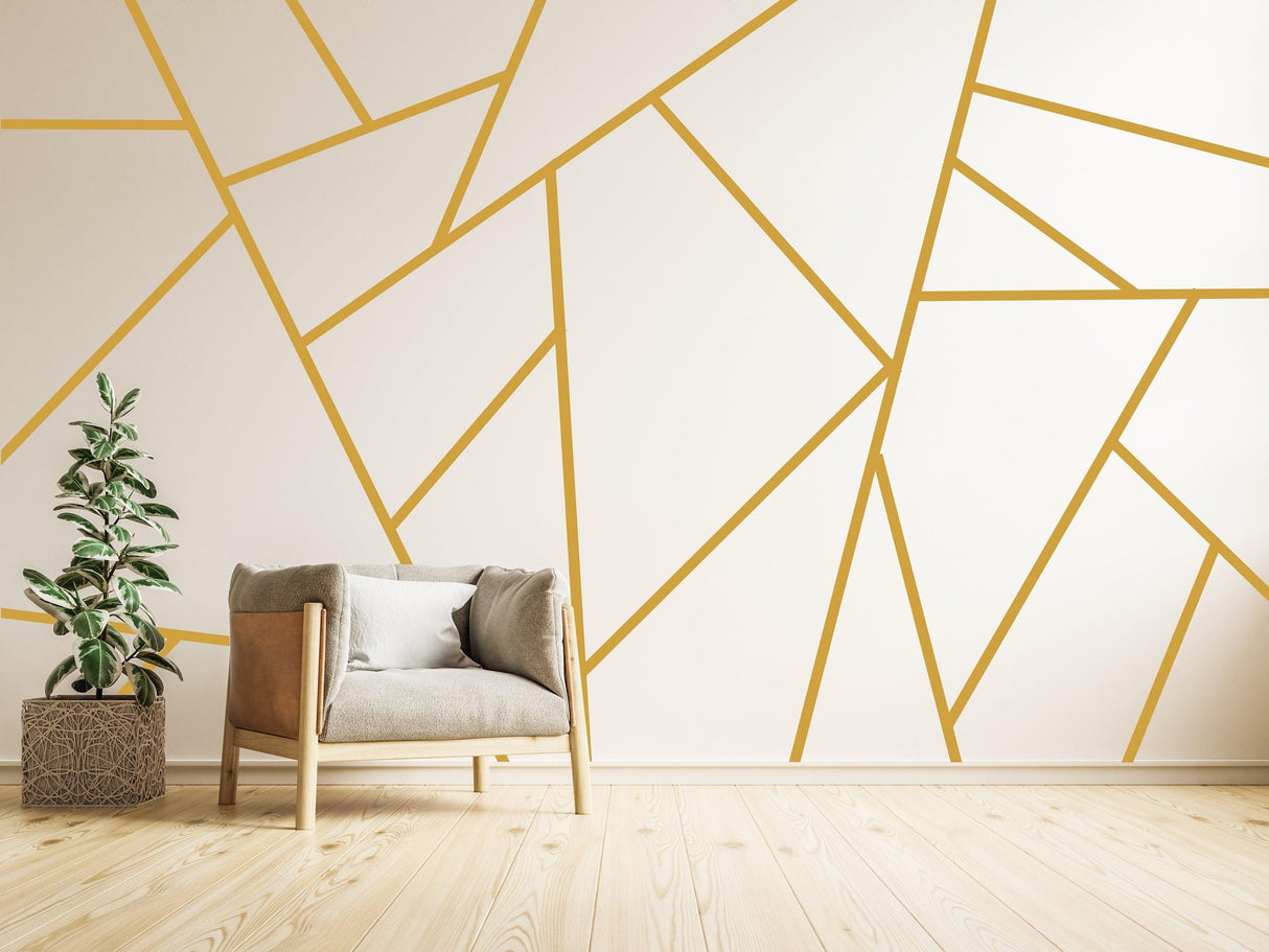 Stylish room featuring gold peel and stick wall decals in geometric design with a cozy chair and plant.