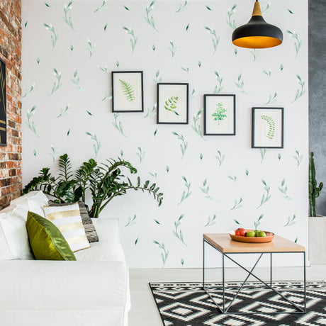 Living room featuring botanical olive leaf wall stickers, framed art, and a cozy couch for a fresh, natural decor.