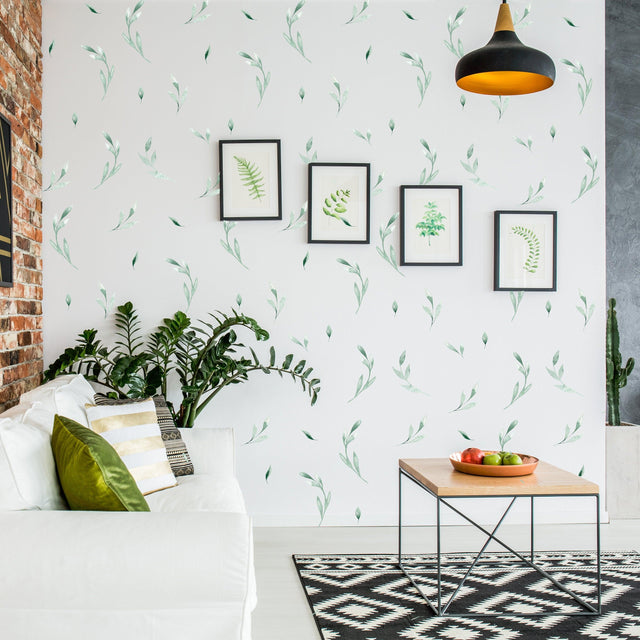 Living room featuring botanical olive leaf wall stickers, framed art, and a cozy couch for a fresh, natural decor.