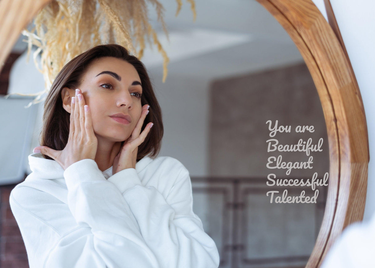 Mirror affirmation quote vinyl decal with inspirational words on a bathroom mirror and a woman applying skin care.
