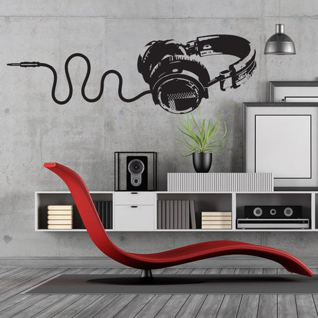 Stylish black headphones vinyl wall sticker in modern living room with red lounge chair and speakers.