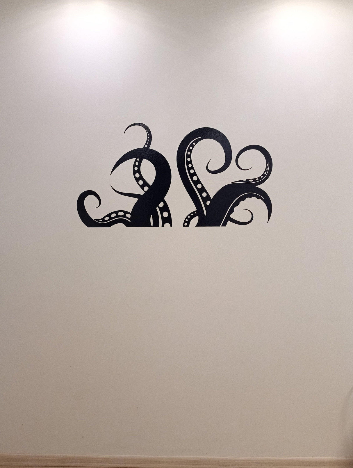 Octopus tentacles vinyl wall art sticker on a light wall, adding ocean-inspired decor to a bathroom space.
