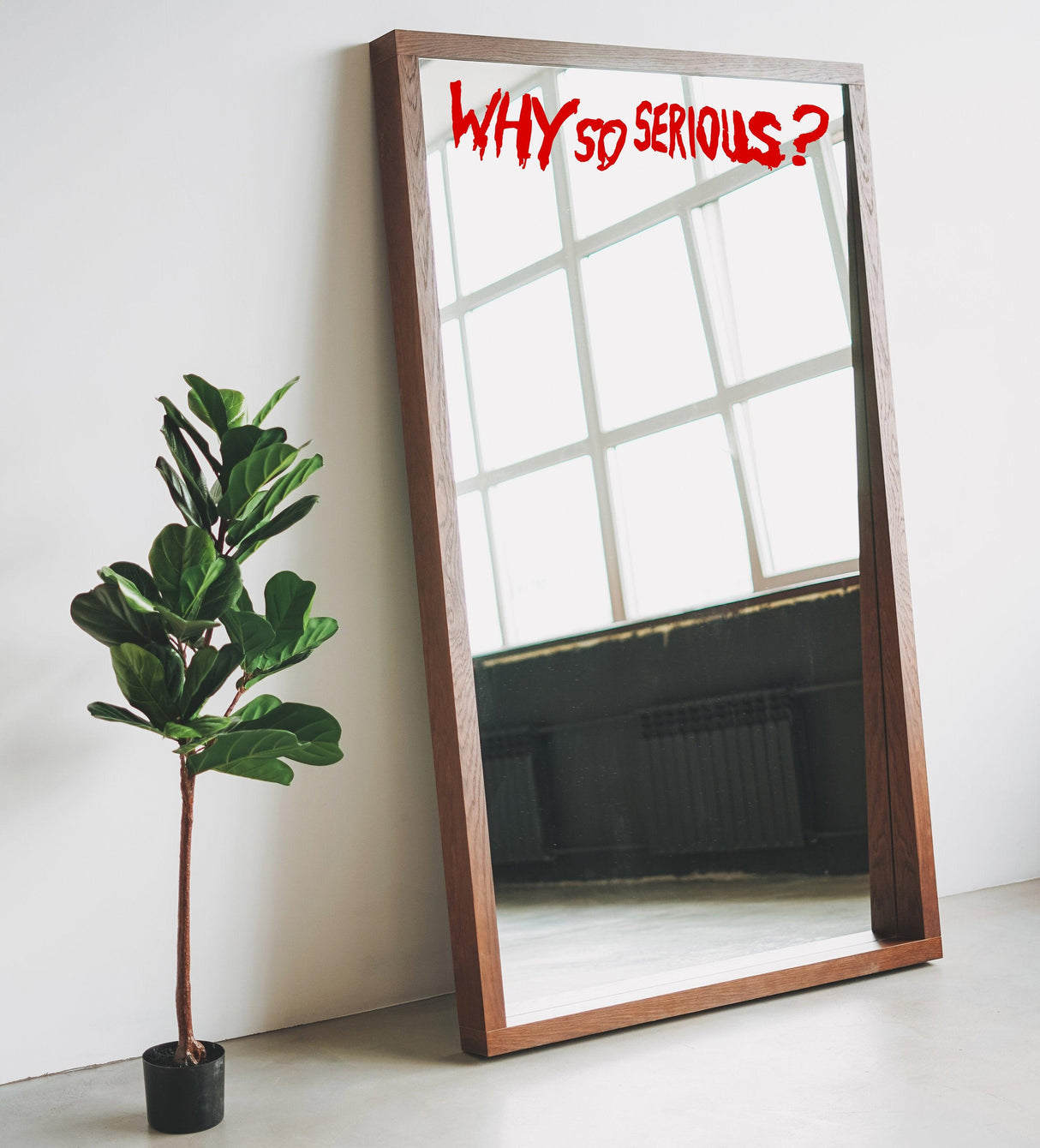 Mirror with 'WHY so SERIOUS?' vinyl sticker above a plant, perfect for fans of the Joker villain theme.